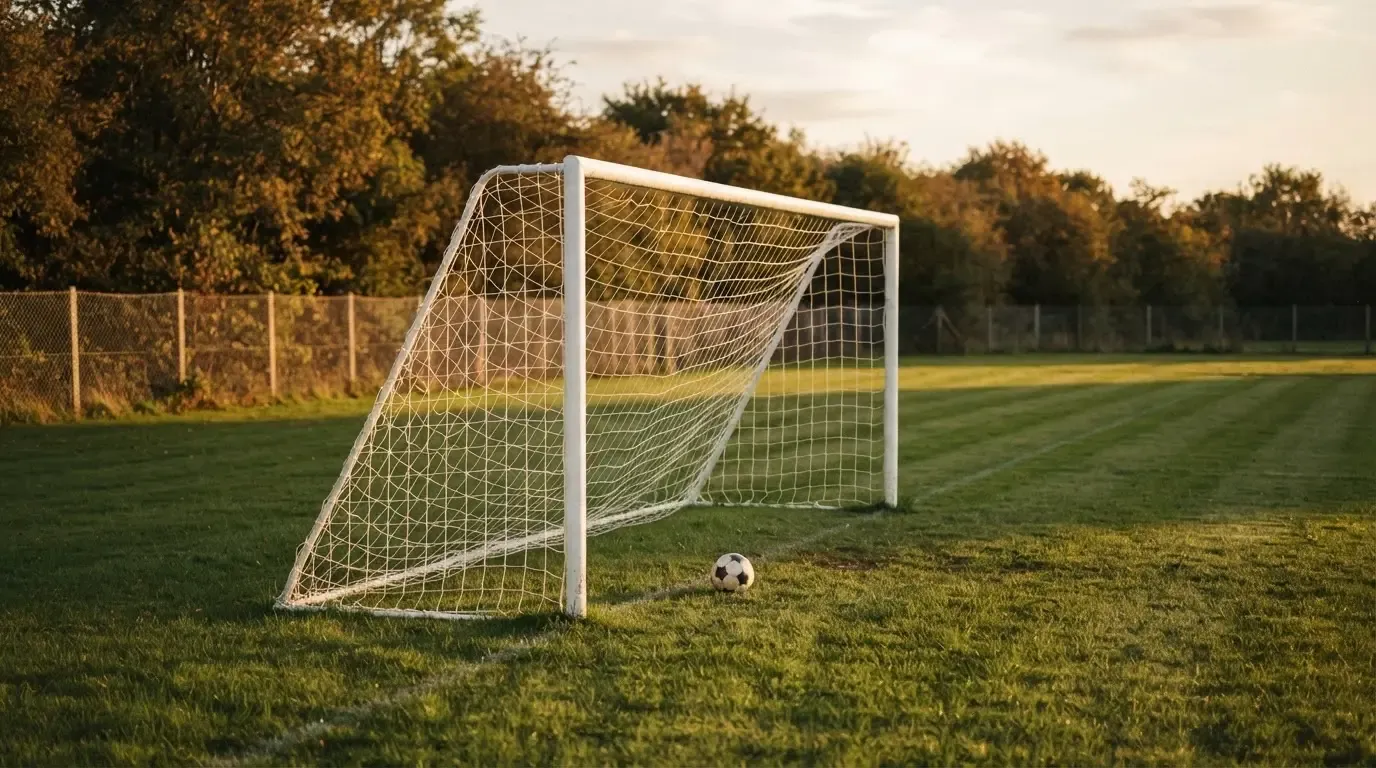 Ein Fussballtor mit locker hängendem Netz auf einem Trainingsplatz, das sich leicht im Wind bewegt.